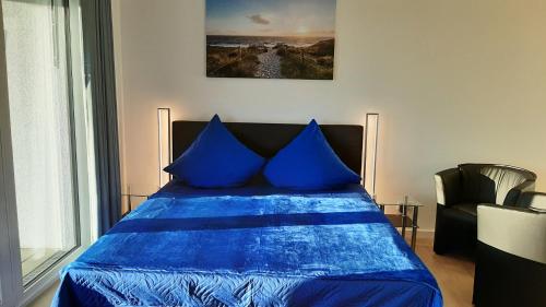 阿尔特费尔Apartment 10 in Altefähr am Strelasund的卧室内的蓝色床和蓝色枕头
