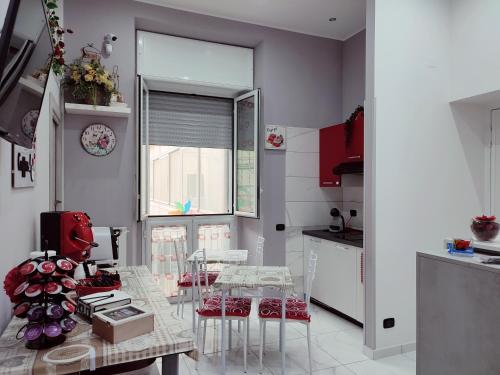 那不勒斯B&B May Dream的厨房配有桌椅和窗户。