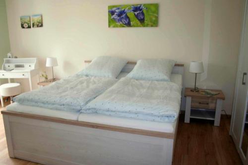奥茨塞巴德·迪尔哈根Lachmöwe App 35的一间卧室配有白色的床铺和蓝色的床单