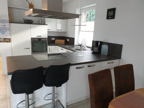奥尔登堡Ferienwohnung Reinhardt的厨房配有白色橱柜和黑色台面