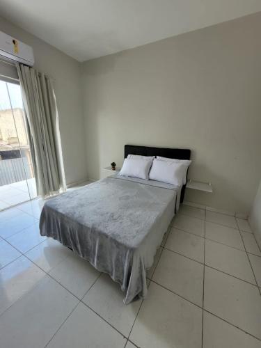 科伦巴Sobrado 4 amplo e confortável em condomínio的一间卧室设有一张床和一个大窗户
