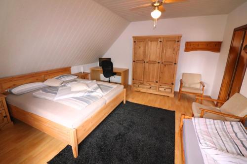 海德瑙Ferienwohnung am Barockgarten的一间卧室配有一张床、一张桌子和一把椅子