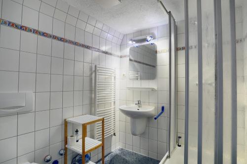 青斯特Altes Wasserwerk, App 5的白色瓷砖浴室设有水槽和镜子