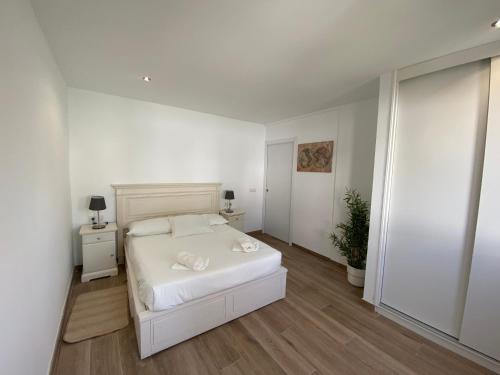 圣米格尔德阿沃纳Residencial Bitacora的白色卧室配有白色的床和植物