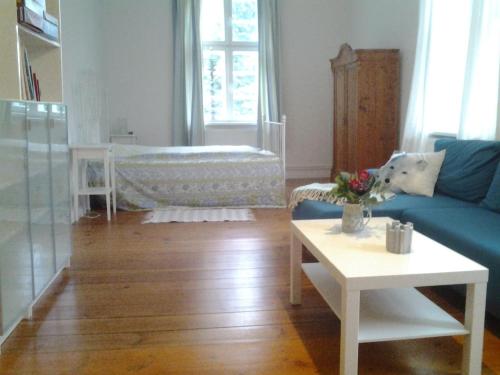 马尔洛Ferienwohnung "Im Pfarrhaus Marlow"的客厅配有蓝色沙发和婴儿床