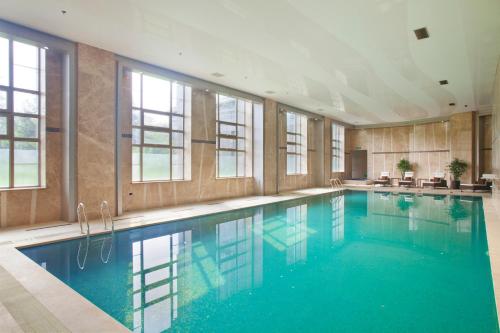 牡丹江牡丹江世茂假日酒店的大楼内一个蓝色的大型游泳池