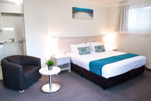 Copacabana科帕卡巴纳海岸公寓式酒店的配有一张床和一把椅子的酒店客房