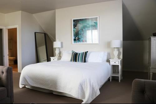 格雷敦Briarwood的卧室配有一张带两盏灯和镜子的白色床。
