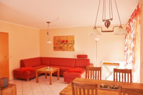 卡尔斯哈根Pepes Ferienwohnung的客厅配有红色的沙发和桌子