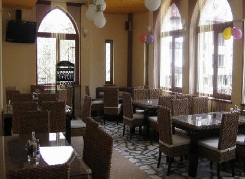 萨莫科夫卡斯特尔酒店的用餐室设有桌椅和窗户。