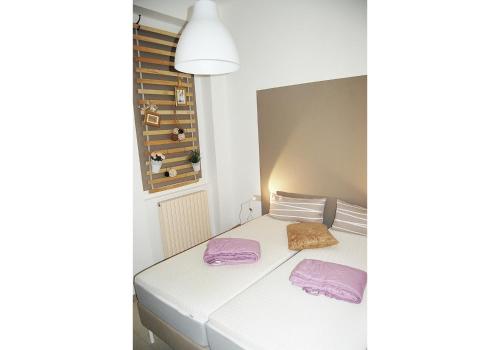 Perticarada Marianna的卧室配有白色床和紫色毛巾