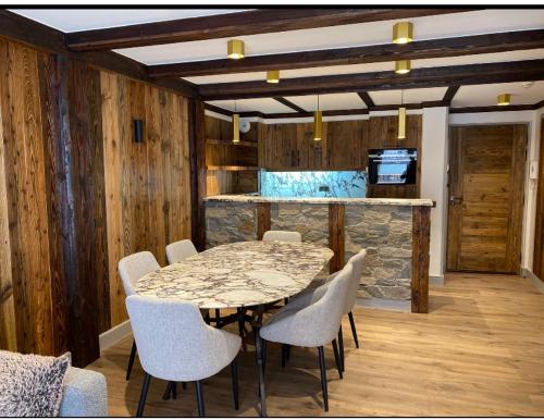 谷雪维尔Luxury suite 70m2 balcon courchevel1850 parking的一间配备有大理石桌椅的用餐室