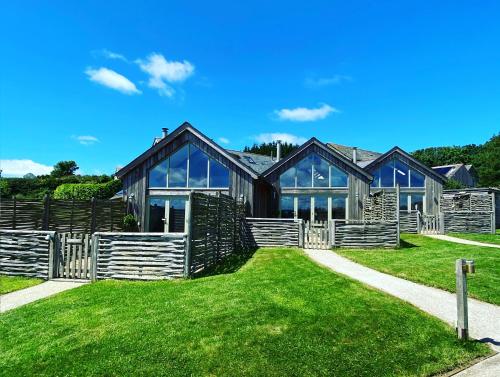 马根波思Merlin Farm Cottages short walk to Mawgan Porth Beach and central location in Cornwall的绿色草坪上的大型木屋