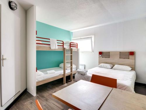 布尔日HotelF1 Bourges Le Subdray的客房设有两张双层床和一张桌子。