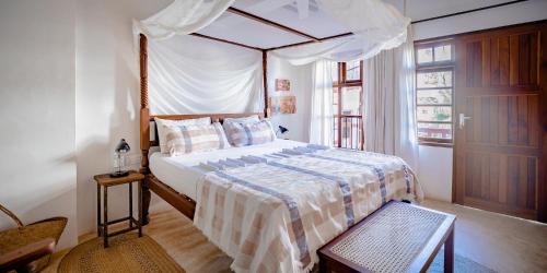 拉穆Jua House的一间卧室配有一张带天蓬的床