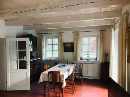 BardowickVesta Waldhaus Bardowicker Heide的一间带桌椅和窗户的用餐室