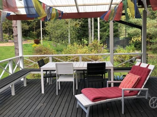 InkooHimalayan cabin Inkoo的一个带桌椅和遮阳伞的甲板