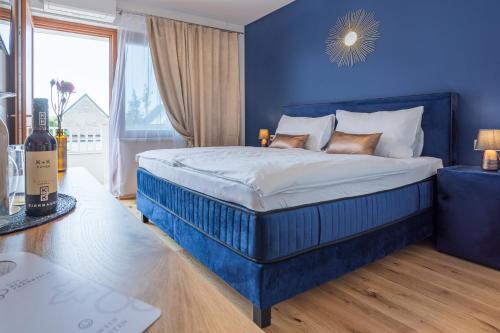 GirmDas Blaufränkisch Weinhotel & Restaurant的蓝色的卧室,配有一张蓝色墙壁的床
