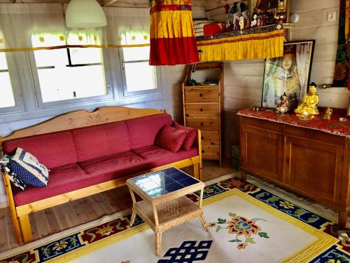 InkooHimalayan cabin Inkoo的客厅配有红色的沙发和桌子