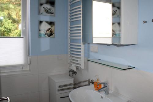 奥茨塞巴德·迪尔哈根Seeschwalbe App 34的一间带水槽和镜子的浴室以及窗户。