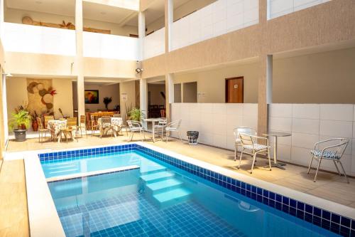 特里温福Hotel Encanto do Sertão的游泳池配有桌椅和桌椅