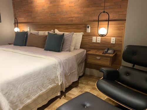 伊泰帕瓦Granja Brasil的配有一张床和一把椅子的酒店客房