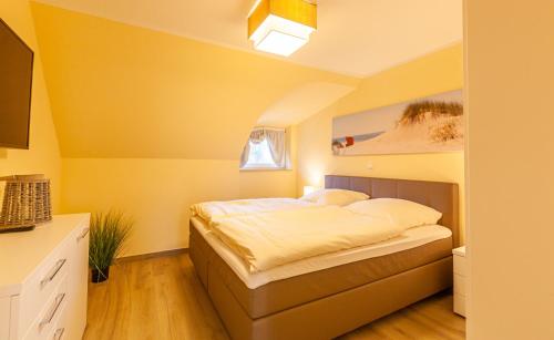 青斯特Seeadler - a26427的黄色间内一间卧室,配有一张床