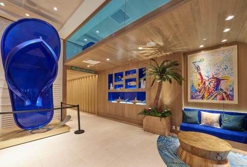 纽约Margaritaville Resort Times Square的大堂设有大型蓝色花瓶和桌子