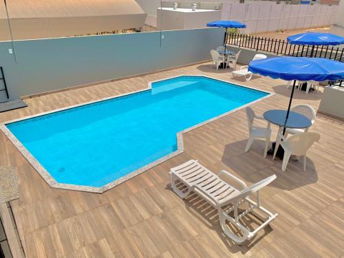 巴雷拉斯Principe Hotel的一个带桌椅和遮阳伞的大型游泳池