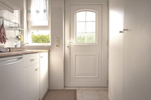 富伦多夫FeWo Kranich的厨房设有白色的门和窗户