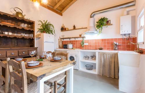 埃尔博斯克Encantadora casa rural con piscina privada的厨房配有木桌和水槽。