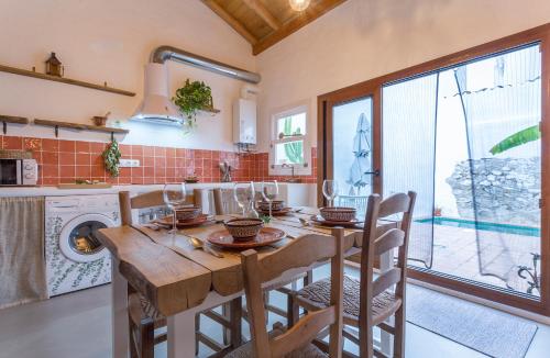 埃尔博斯克Encantadora casa rural con piscina privada的厨房配有木桌、椅子和水槽