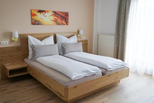 塞博登帕比勒尔旅馆的卧室配有一张带白色床单和枕头的大床。