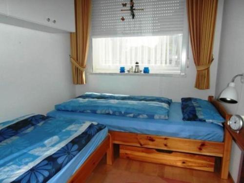 布尔哈沃Fewo 91 WHG B 18 in Burhave的一间卧室设有两张单人床和一个窗户。