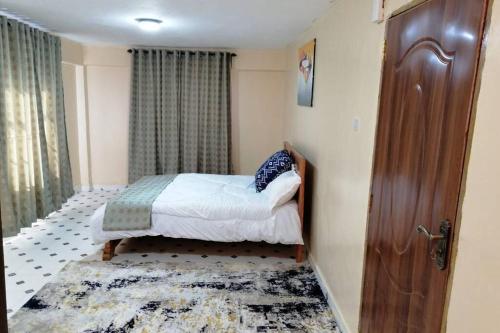 KisiiLass Grove Home的一间小卧室,配有一张床和一扇门