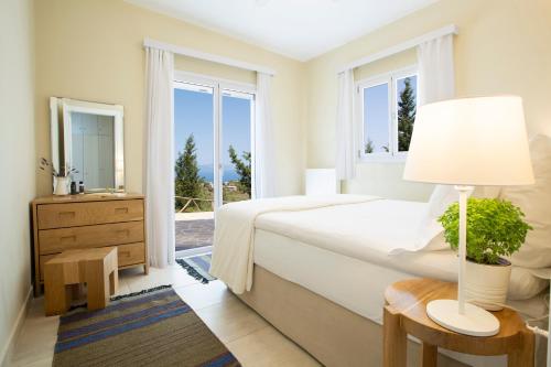 苏卡雷斯Boo Premium Living Villas的白色的卧室设有床和窗户