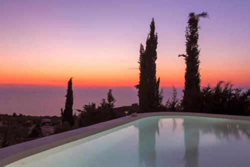 苏卡雷斯Boo Premium Living Villas的一座享有日落美景的游泳池