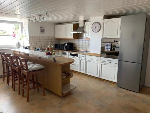 梅明根阿尔高公寓式酒店的厨房配有白色橱柜、冰箱和桌子