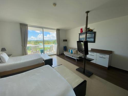 普拉亚布兰卡The Suite Playa Blanca的酒店客房设有两张床和一台平面电视。
