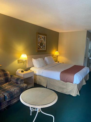 梅里迪恩Americas Best Value Inn (Meridian)的酒店客房带两张床、一张桌子和一张沙发