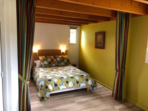 普洛埃尔梅勒Cottage Anadwen au pied du lac au duc et son golf的卧室配有一张床铺,位于一个黄色墙壁的房间