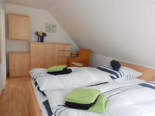 普雷罗Hinter den Dünen D60的一间设有三张床的客房,备有毛巾