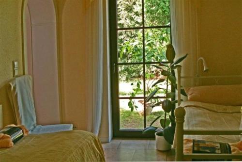 霍佩加尔滕Mediterran Suite的卧室设有窗户、床和植物