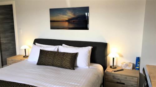 白沙滩斯托姆湾住宿加早餐旅馆的一间卧室配有一张带2个床头柜和2盏灯的床。