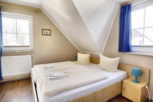 青斯特Am Deich 32的一张位于带蓝色窗户的房间内的床铺