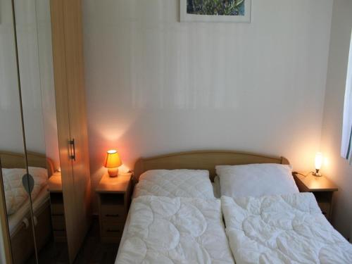 奥茨塞巴德·迪尔哈根-"Strandkrabbe" in der App-Anlage "Parkresidenz Dierhagen"-的一间小卧室,配有两张床和两盏灯
