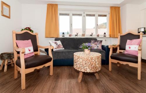 巴特维塞Baumgartenschneid的客厅配有沙发、两把椅子和一张桌子
