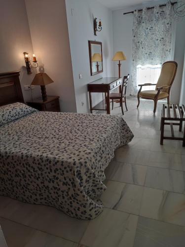 巴达霍斯塞万提斯酒店的卧室配有一张床和一张桌子及椅子