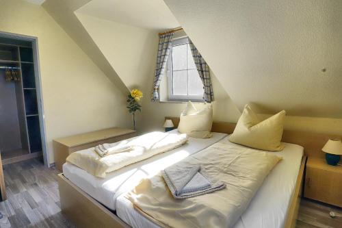 青斯特Am Deich 50的一间卧室配有两张床、毛巾和窗户