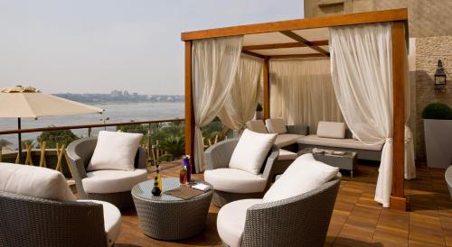 开罗Holiday Inn Cairo Maadi, an IHG Hotel的阳台配有椅子,享有水景